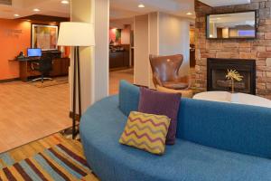 Sofá azul en el vestíbulo con chimenea en Fairfield Inn & Suites by Marriott Lexington Georgetown/College Inn, en Georgetown