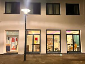 uma luz de rua em frente a um edifício com janelas de vidro em Hotel Madeleine Biohotel em Saarbrücken