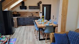 a dining room with a wooden table and blue chairs at wellness roubenka Holčí in Miřetice