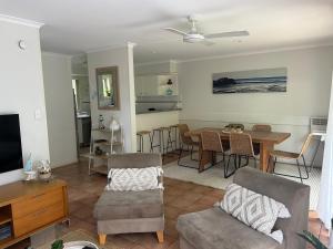 a living room with a table and a dining room at Beach Haven @ Diggers in Coffs Harbour
