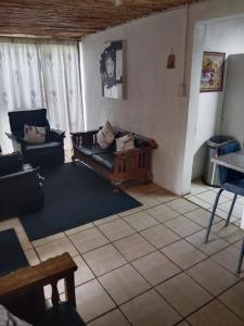 salon z kanapą i stołem w obiekcie Non Stop Adventures Weaver Cottage w mieście Pietermaritzburg
