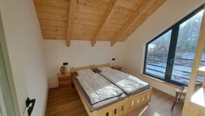 a bedroom with a bed and a large window at wellness roubenka Holčí in Miřetice