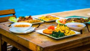 uma mesa com muitos pratos diferentes de comida em Roma Stays - Classy Studio Apartment in Nyali ( Opp Shell Links Road) em Mombasa