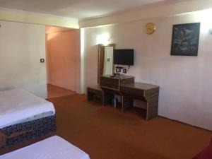 Ishaan Resort في مانالي: غرفة في الفندق مع مكتب ومرآة