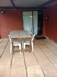 una mesa de madera y sillas en un patio en Non Stop Adventures Weaver Cottage, en Pietermaritzburg