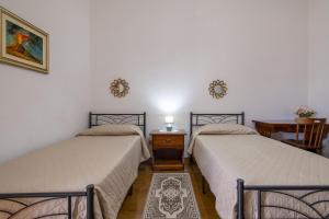 twee bedden naast elkaar in een kamer bij Nausica's Apartment in Trinità dʼAgultu