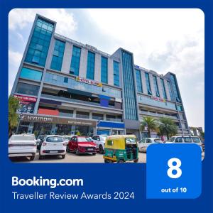 a building with cars parked in a parking lot at FabHotel Bliss in Ahmedabad