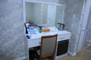 escritorio en una habitación con espejo en HOBIZ Hotel en Navoi