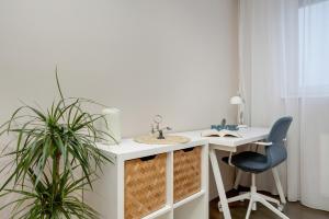einen weißen Schreibtisch mit einem Stuhl und einem Waschbecken in der Unterkunft Blue Apartment Słowackiego with Balcony and Parking in Gdańsk by Renters in Danzig