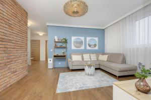 a living room with a couch and a brick wall at Blue Apartment Słowackiego with Balcony and Parking in Gdańsk by Renters in Gdańsk