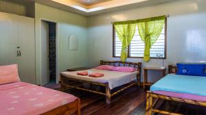 um quarto com duas camas e uma janela em High Chaparral Cottages em El Nido