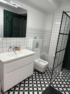 Baño blanco con lavabo y aseo en Cozy one bedroom apartment in New Gudauri, en Gudauri