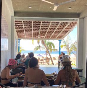 Talalla Bay Beach في تالالا ساوث: مجموعة من الناس يجلسون على الطاولات في مطعم الشاطئ