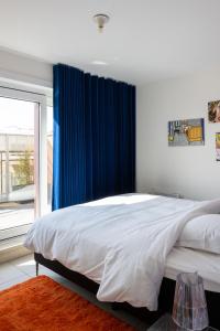 um quarto com uma cama grande e cortinas azuis em ROOFTOP em Oostende