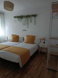 1 dormitorio con 2 camas y plantas en la pared en Casa Cobo Exclusivo Alojamiento en Madrid, en Madrid