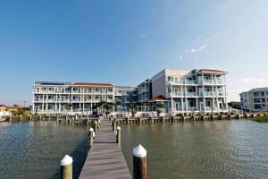 a building on the water with a dock and buildings at Fairfield Inn & Suites by Marriott Chincoteague Island Waterfront in Chincoteague