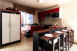 a kitchen with red cabinets and a white refrigerator at Casa Blanca in Santa Gertrudis