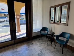 a room with two chairs and a table and windows at Historic Sonora Inn in Sonora