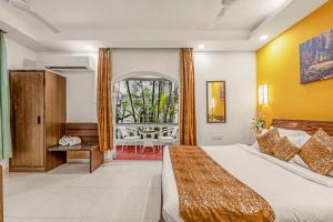 a hotel room with a large bed and a table at Joia Do Mar Resort - Calangute in Calangute