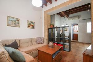 ein Wohnzimmer mit einem Sofa und einem Tisch in der Unterkunft Precioso Apart. Céntrico y confortable **Wifi-AC** in Sevilla