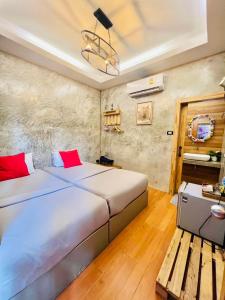 a bedroom with a large bed and a wooden bench at SAMED GRAY HOUSE in Ban Phe