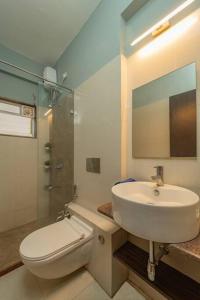 a bathroom with a sink and a toilet and a mirror at Earthlings : Anjuna beach- 2BHK with swimming pool in Anjuna