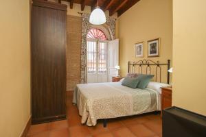 Schlafzimmer mit einem Bett und einem Fenster in der Unterkunft Precioso Apart. Céntrico y confortable **Wifi-AC** in Sevilla