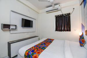 a small bedroom with a bed and a tv at FabHotel Green Leaf I in Kolkata