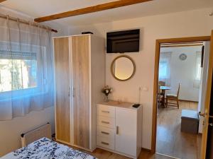 um quarto com uma cómoda e um espelho em Apartman Krajcer 