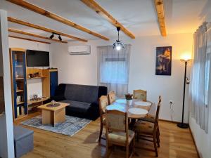 a living room with a table and a couch at Apartman Krajcer 