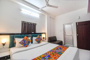 a bedroom with a large bed and a chair at FabHotel Green Leaf I in Kolkata