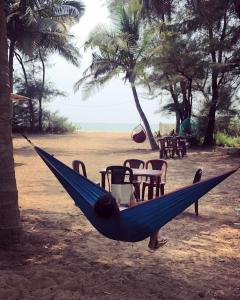 a person in a blue hammock on a beach at Blue Lagoon Redefined in Gokarna