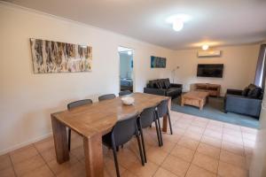 a living room with a wooden table and chairs at Margaret River Tourist Park in Margaret River Town