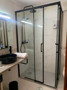 a glass shower in a bathroom with a sink at Hotel Carbayon in Oviedo