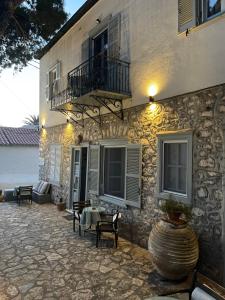 a stone building with a balcony and a patio at Piteoussa rooms in Hydra