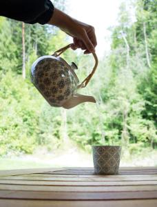 a person is pouring water into a tea pot at Haus Schatzl mit Gartenanteil und Bademöglichkeit im Fluss in Bad Aussee +227 photos