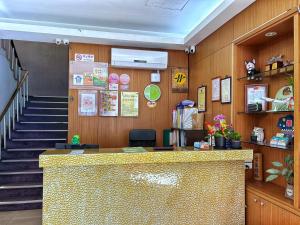 a lobby of a restaurant with a counter and stairs at Fulong Hotel in Zhongli