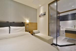 釜山的住宿－Hotel Brooks Busan Gijang，一间卧室配有一张床、淋浴和盥洗盆