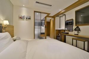 釜山的住宿－Hotel Brooks Busan Gijang，一间带白色床的卧室和一间厨房