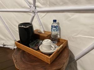 een houten dienblad met een fles water op een tafel bij Glamping @ Pebbles & Fins in Kubu