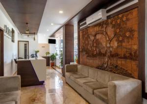 Airport Avenue Plaza Cochin Airport في نيدومباسيري: غرفة معيشة مع لوحة كبيرة على الحائط