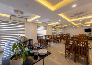 Airport Avenue Plaza Cochin Airport في نيدومباسيري: غرفة طعام مع طاولات وكراسي في مطعم