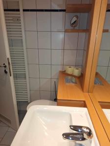een badkamer met een witte wastafel en een spiegel bij Villa Sonneck App03 in Ostseebad Sellin