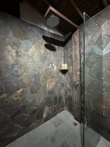 een badkamer met een douche en een glazen deur bij Glamping @ Pebbles & Fins in Kubu