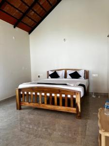 um quarto com uma cama de madeira num quarto em Coorg Coffee Inn em Suntikoppa