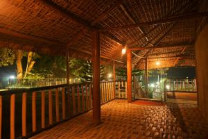Gorh Retreat في كازيرانغا: شرفة خشبية مع سقف مع أضواء عليه