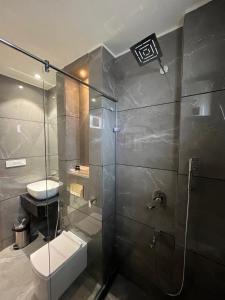 y baño con ducha, aseo y lavamanos. en Hotel Three Seasons en Vrindāvan