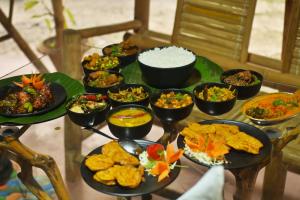 einen Tisch mit verschiedenen Lebensmitteln auf Platten in der Unterkunft Gorh Retreat in Kāziranga
