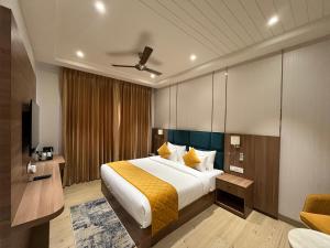 Habitación de hotel con cama y TV en Hotel Three Seasons en Vrindāvan