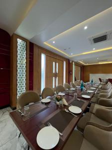 une grande salle de conférence avec une grande table et des chaises dans l'établissement Hotel Three Seasons, à Vrindavan